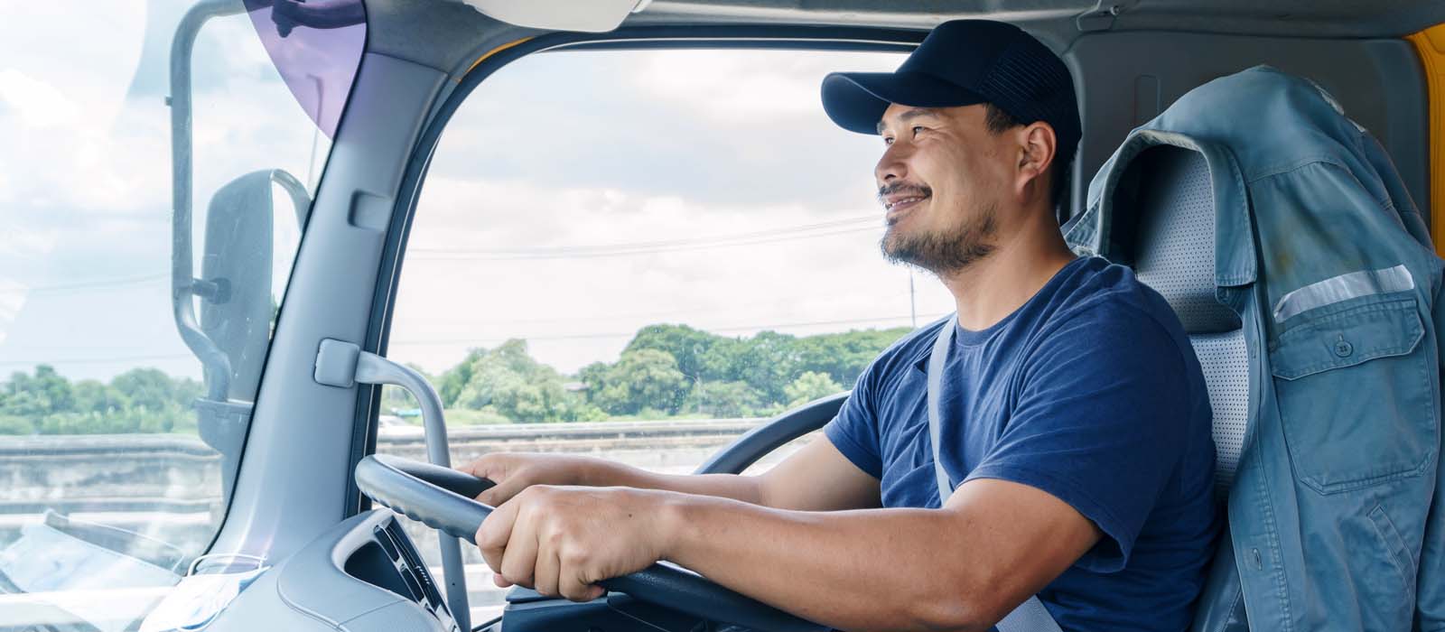 trucker in orange hat driving