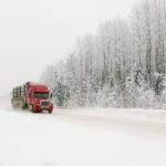 a truck drives on a snowy road in winter