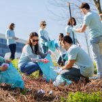 volunteers with garbage bags cleaning park area