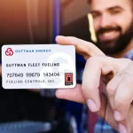 a man holds up a Guttman Energy Fuel Card