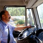 a happy truck driver in his truck's cab.